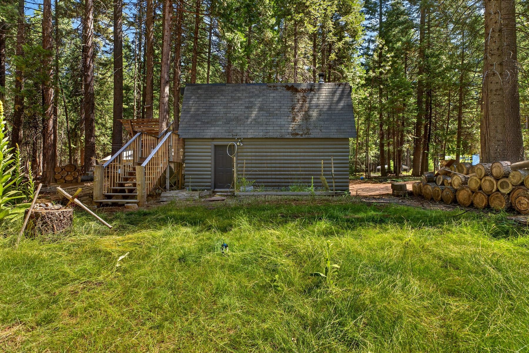 Cabin on a green clearing ringed by tall pines at Thatcher Mill Road in Shingletown